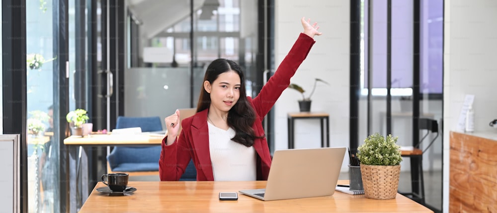 Overjoyed  businesswoman  reading good pleasant news on laptop computer and celebrating success.