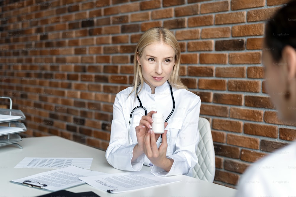 Female nurse explain daily dosage of painkiller medicine. Physician in white coat uniform prescribe drugs or pills to patient, talking with client in office at hospital. Healthcare concept