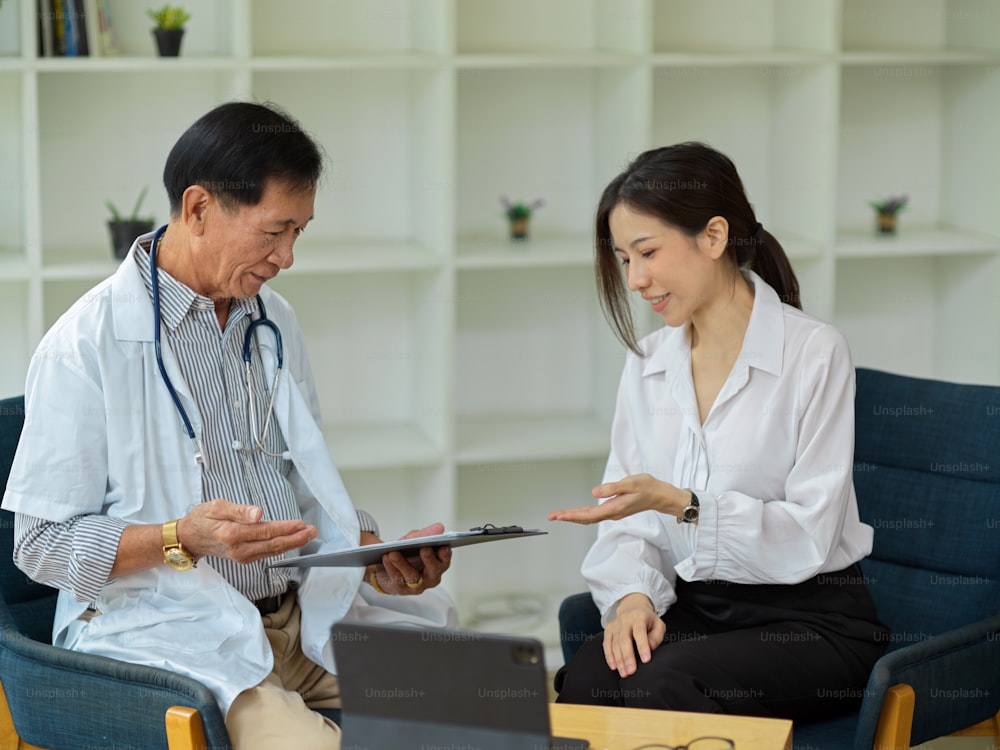 A professional male doctor diagnoses and advises a young female patient. Middled-aged doctor. medical consultation.