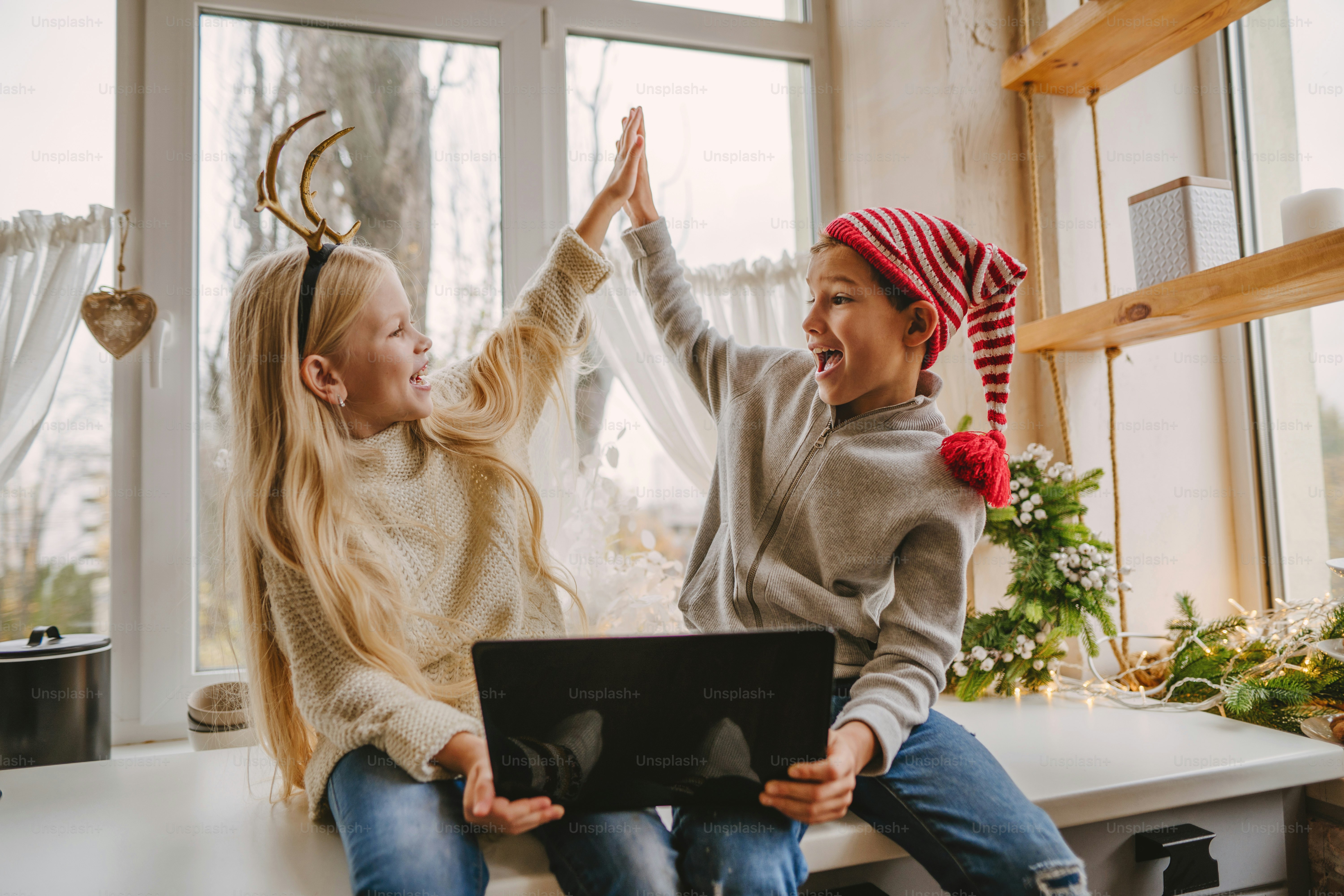 Ragazzo e ragazza che fanno videochiamata usando il laptop a Natale. Messa a fuoco selettiva.