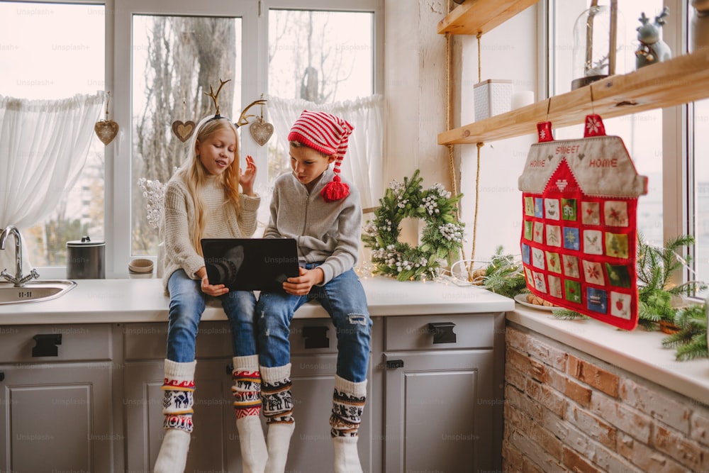 Junge und Mädchen machen Videoanrufe mit Laptop zur Weihnachtszeit. Selektiver Fokus.