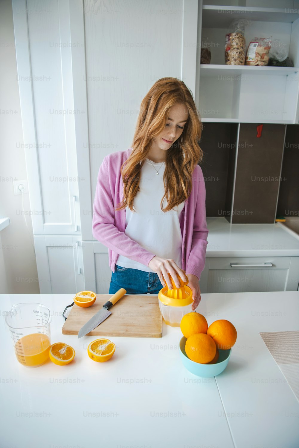 Fruit juice. Woman squeeze fresh juice. Ginger person with freckles working in kitchen.