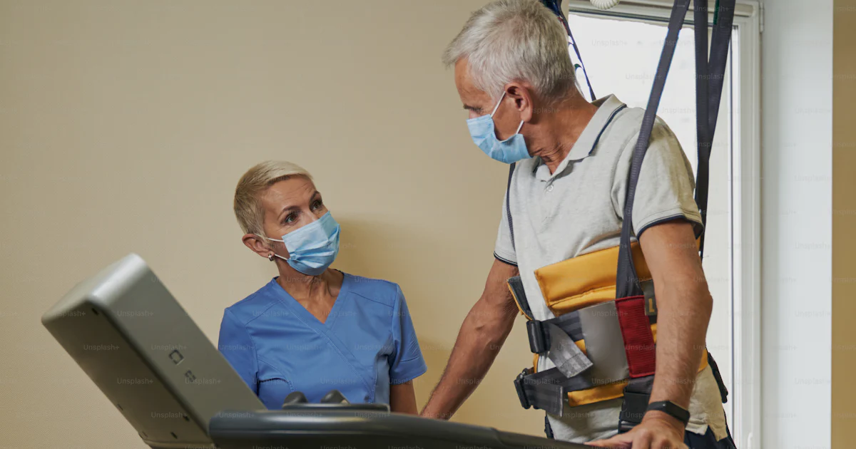 Mobilisation Mask Mature patient on treadmill in face mask using walking harness system ...