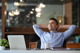 Smiling businessman relaxing in his office.