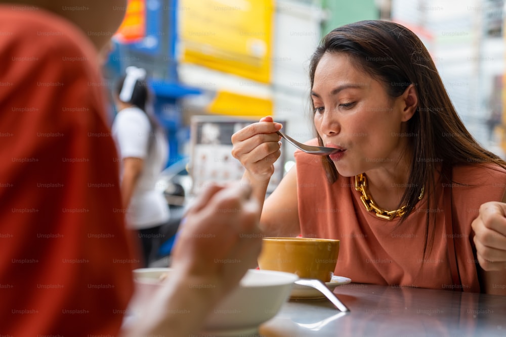 태국 방콕 시내의 차이나타운 거리 야시장에서 함께 저녁을 먹는 아시아 사람들 친구 관광객. 남자와 여자 친구는 야외 라이프 스타일 나이트 라이프와 길거리 음식을 먹는 것을 즐깁니다.