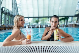 Beautiful women relaxing at the luxury poolside. Female at travel spa resort pool. Summer luxury vacation. Portrait of beautiful woman in swimwear relaxing in swimming pool spa.