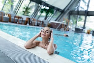 Young beautiful woman enjoying in hot tub while spending relaxing day at health spa.