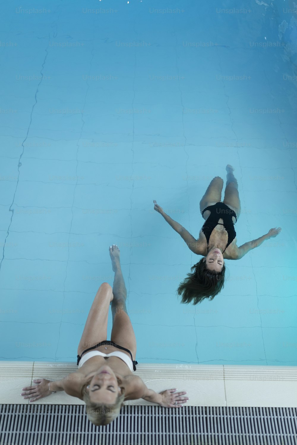 스파의 수영장에서 휴식을 취하고 있는 두 젊은 여성의 뒷모습