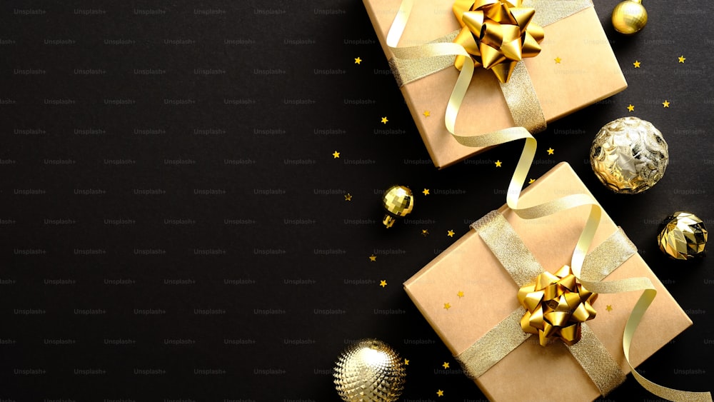 Diseño de banner navideño de lujo. Cajas de regalo planas con cinta dorada, adornos dorados, confeti sobre fondo negro oscuro