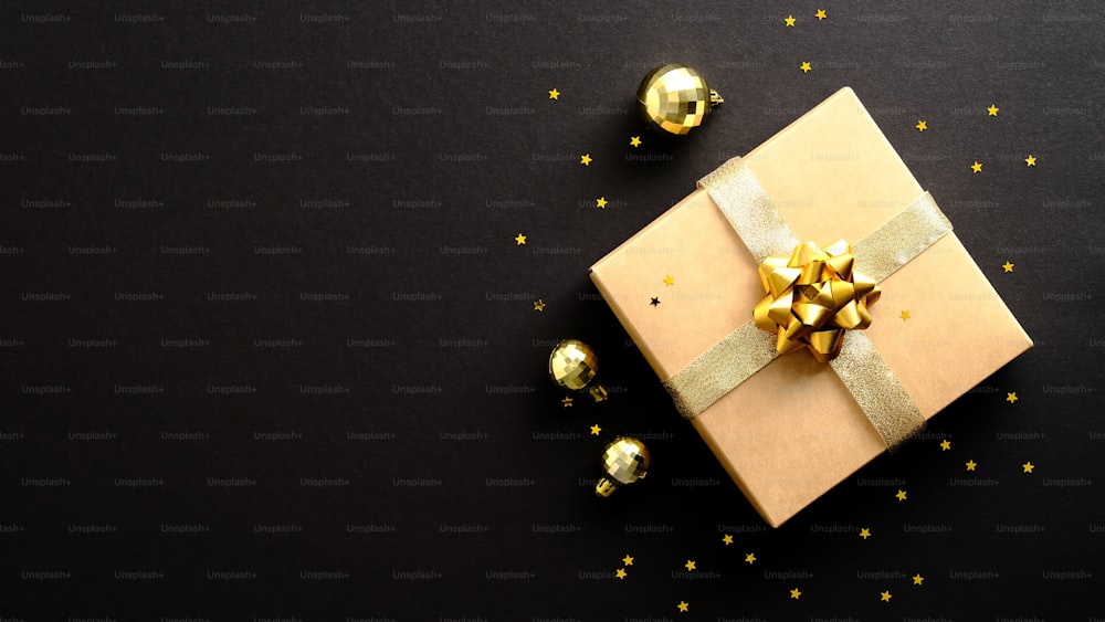 Buon Natale e Felice Anno Nuovo banner design. Confezione regalo, decorazioni palline dorate, coriandoli su sfondo nero scuro.