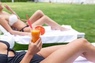 Two women friends at spa resort spending Summer vacation with a cocktail.