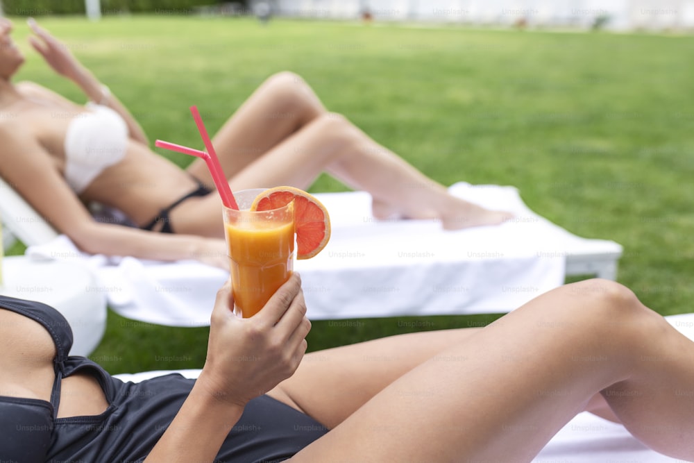 Two women friends at spa resort spending Summer vacation with a cocktail.