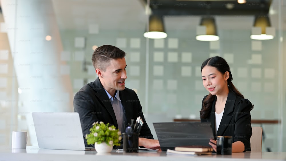 Handsome businessman, bank broker meet with a female entrepreneur to discuss and offer the latest money investment product at her office.