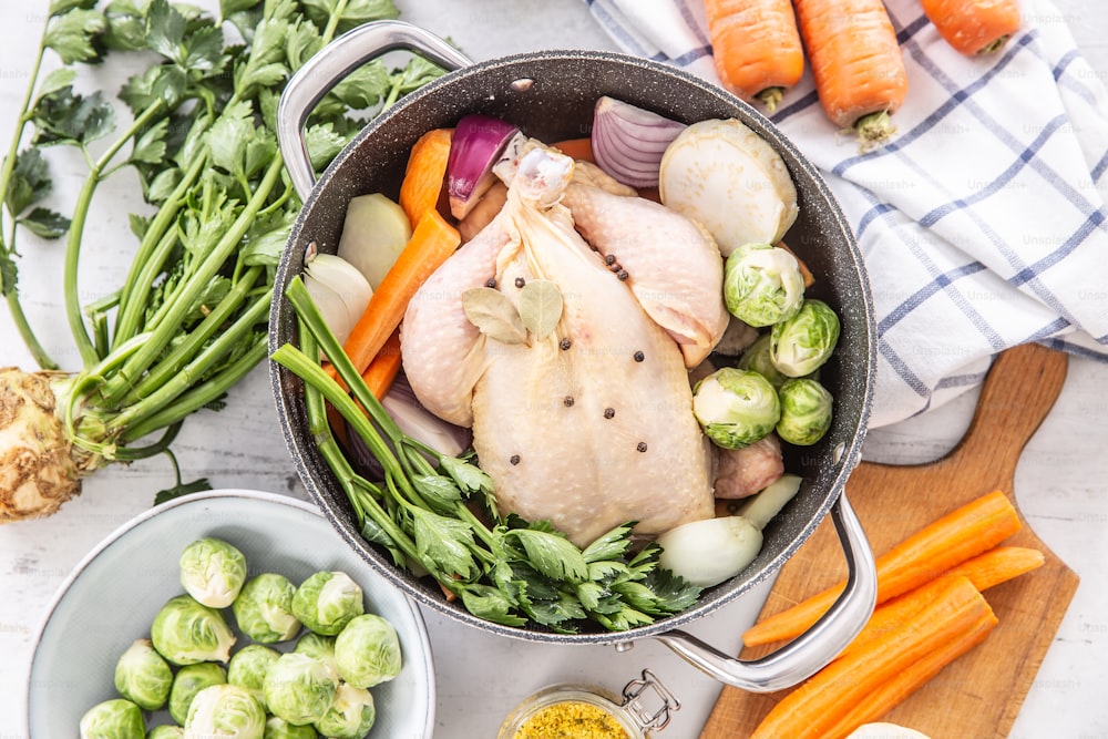 Bouillon de poulet prêt à cuire avec des légumes-racines frais et des épices - vue du haut.