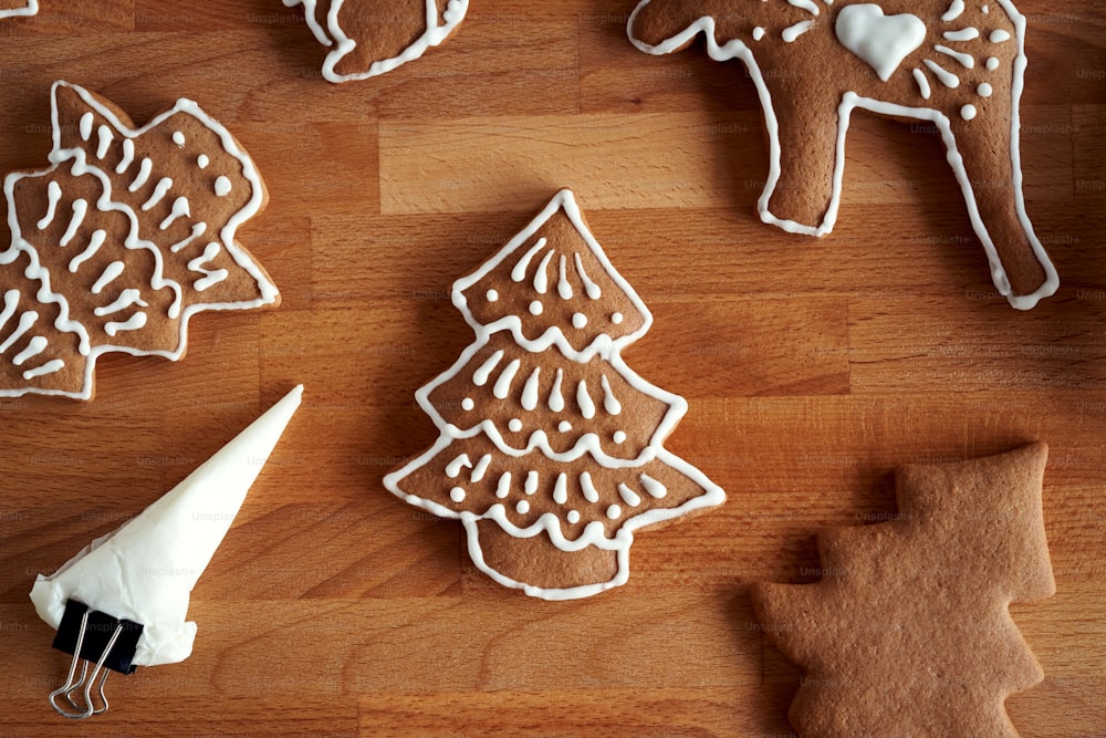 Preparation of homemade gingerbread Christmas cookies - decorating with white icing using a cornet