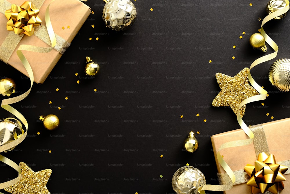 Elegante composizione natalizia piatta lay. Decorazioni dorate, palline, stelle, regali, coriandoli su sfondo nero. Cornice di Natale, design della bandiera, mockup della cartolina d'auguri di Natale