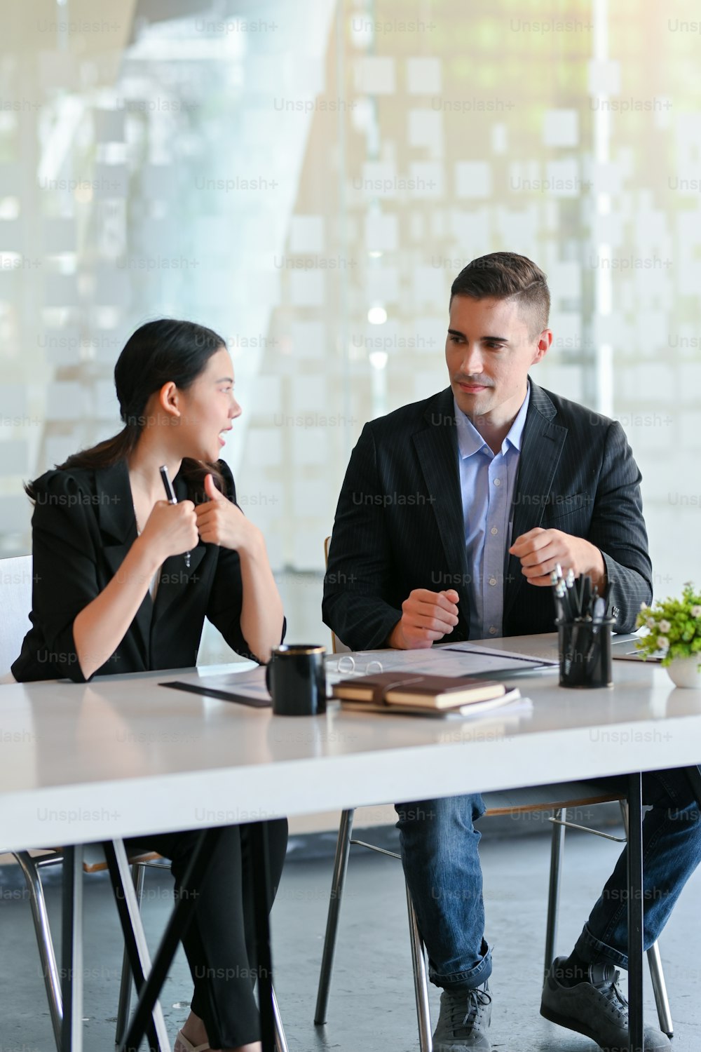 Femme d’affaires et homme d’affaires ayant une grande conversation pendant la pause-café dans un bureau moderne.