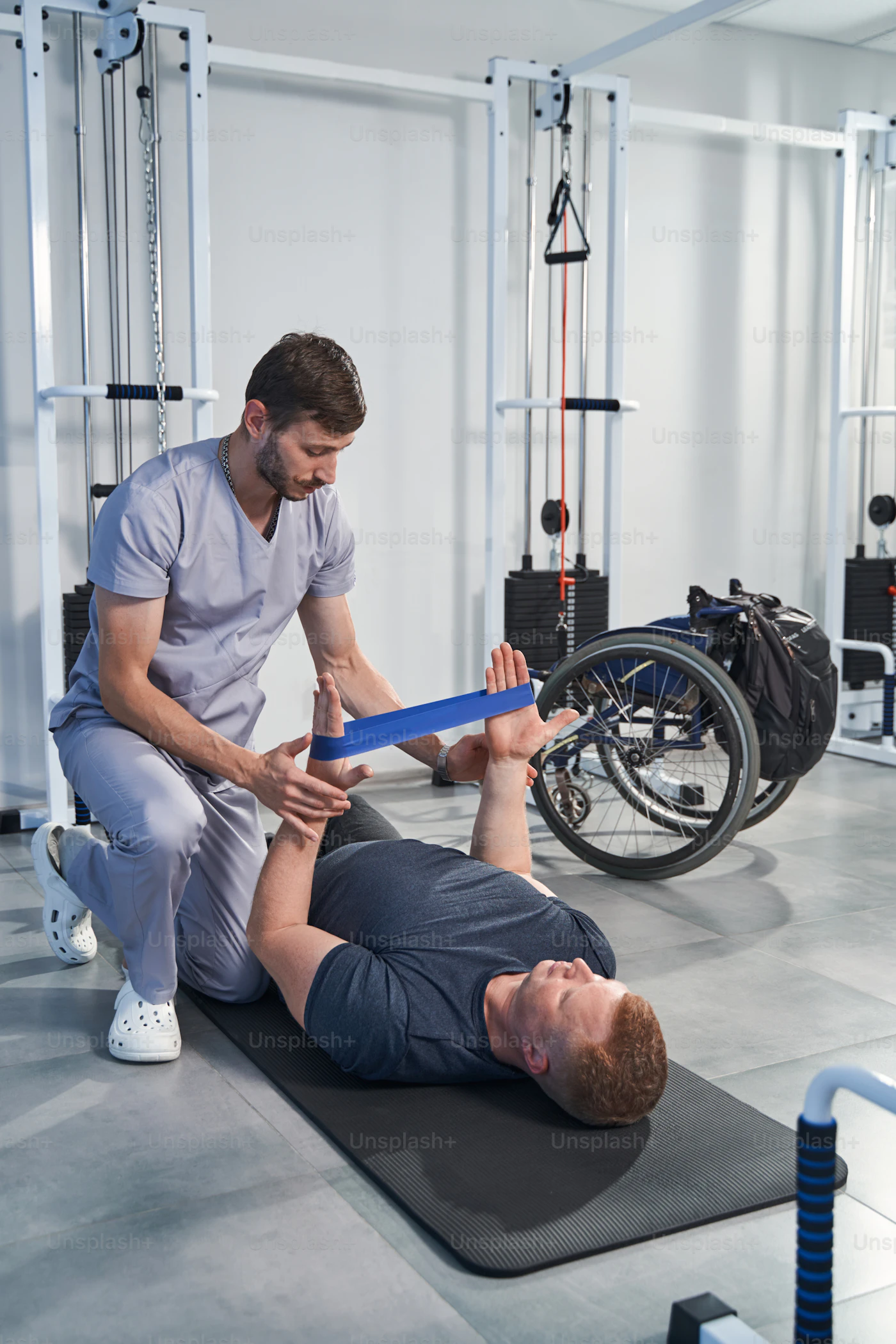 Physical therapist guiding a patient with a resistance band during rehab