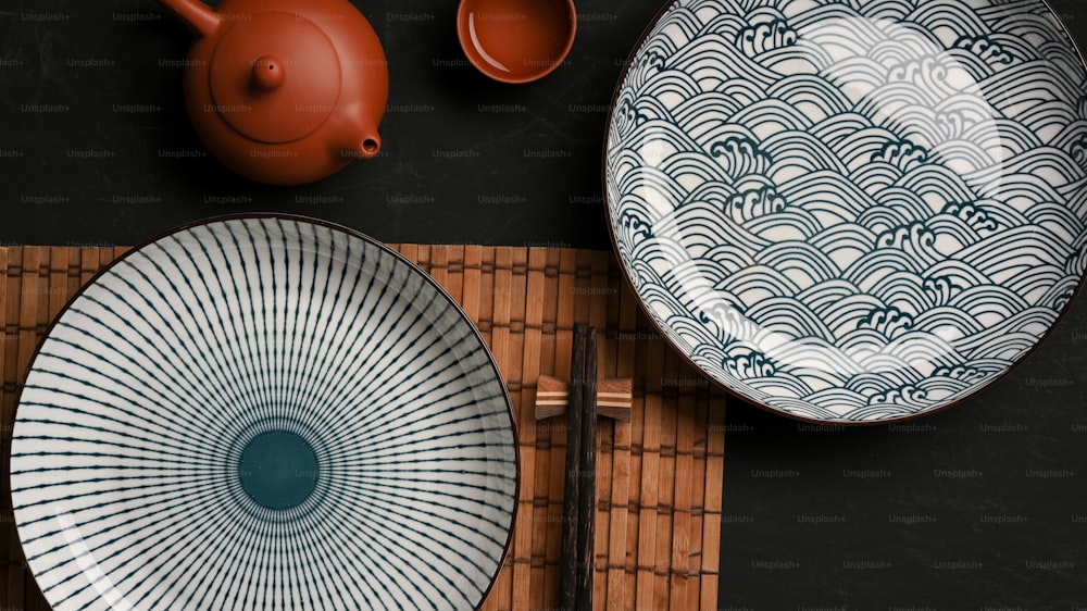 Dressage de table avec de belles assiettes en céramique en porcelaine et un service à thé asiatique sur une table à manger. Vue de dessus
