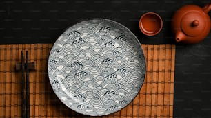 젓가락이 있는 도자기 접시와 식탁에 아시아 차 세트가 있는 아시아 스타일의 테이블 세팅. 상위 뷰