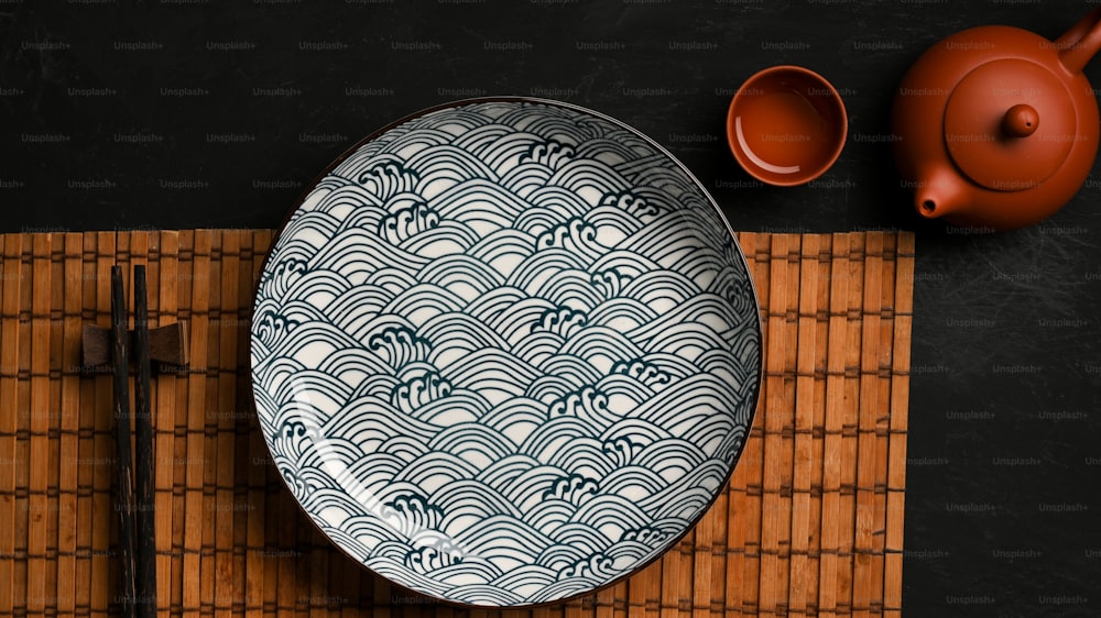 Table setting in asian style with porcelain plate with chopstick and asian tea set on dining table. top view
