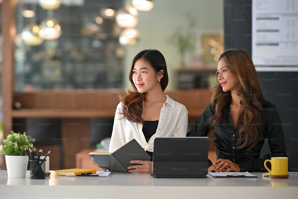 Two elegant female executives are interviewing a new job candidate in board room. Human Resources manager.