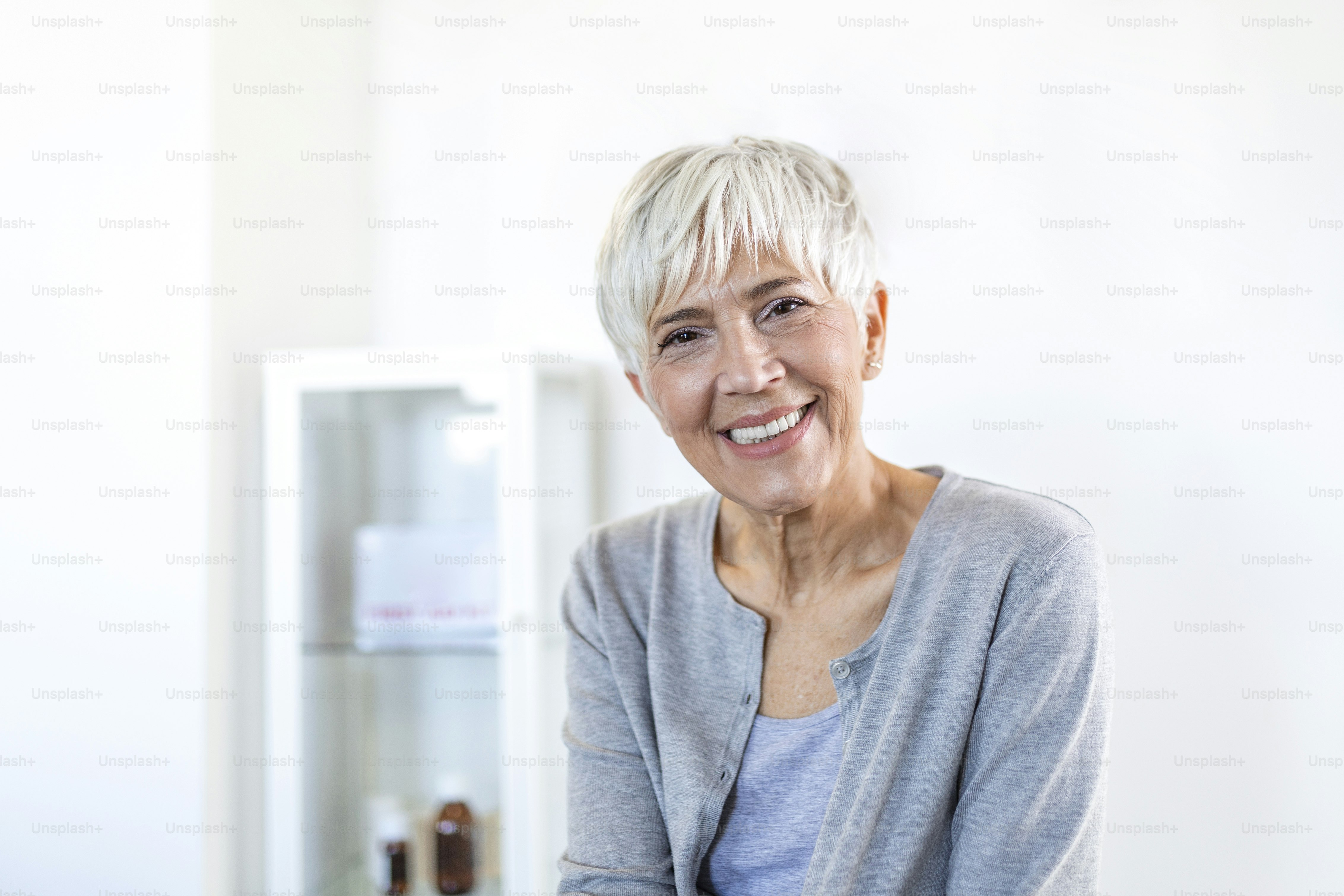 Portrait of smiling middle aged woman looking at camera. Beautiful elderly woman smiling at home.