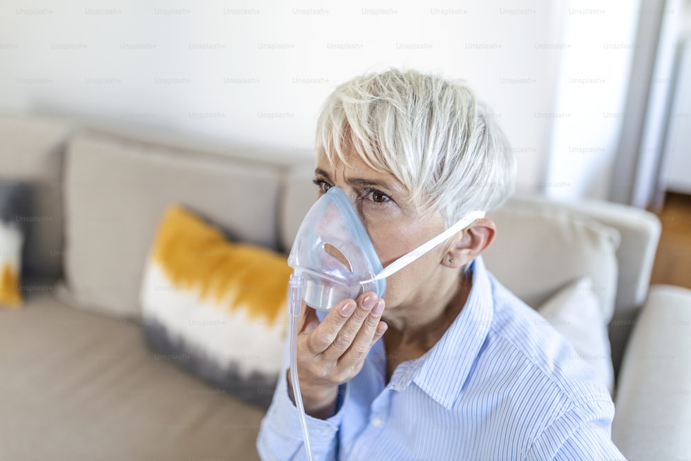 Femme âgée malade sous inhalation de masque à oxygène, pneumonie pandémie de coronavirus. femme âgée malade portant un masque à oxygène et subissant un traitement. Femme âgée atteinte de Covid 19