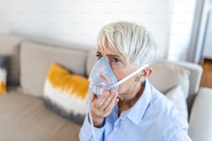 Femme âgée malade sous inhalation de masque à oxygène, pneumonie pandémie de coronavirus. femme âgée malade portant un masque à oxygène et subissant un traitement. Femme âgée atteinte de Covid 19