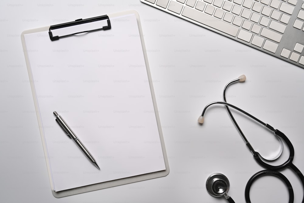 Empty clipboard and stethoscope on white table.