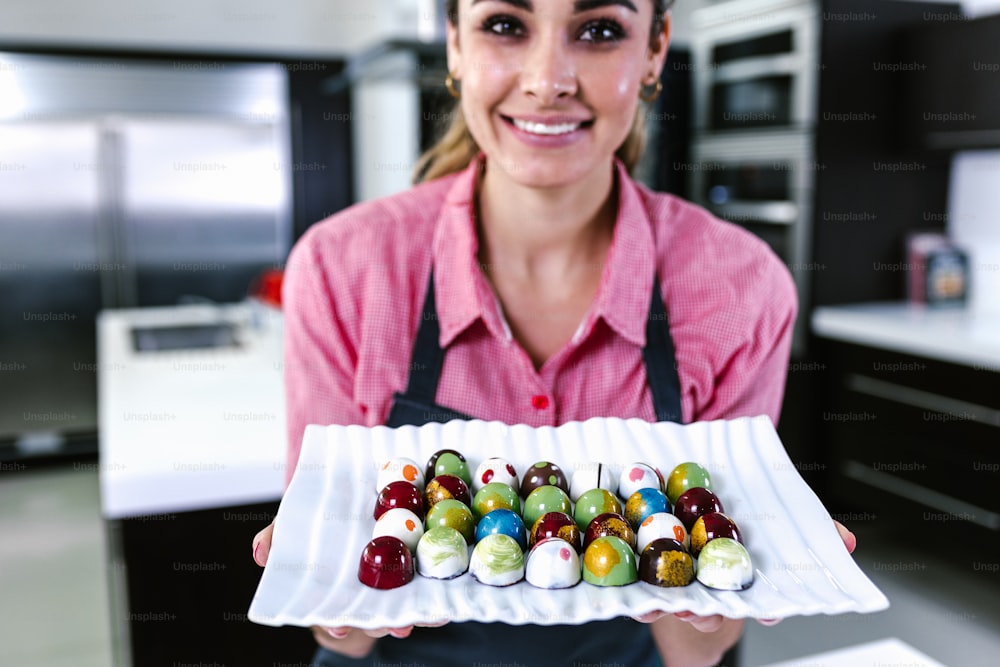 latin young woman pastry chef preparing delicious sweets chocolates at kitchen in Mexico Latin America