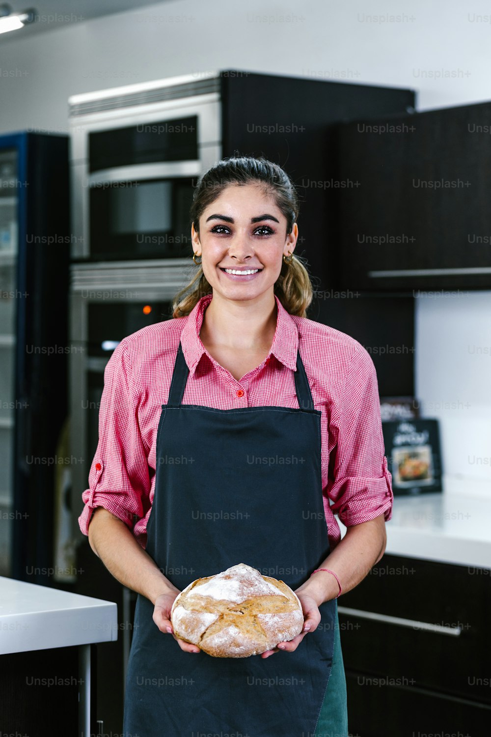 young Latin woman holding piece of bread in kitchen in Mexico Latin America