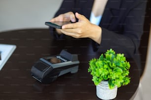 Una donna che usa lo smartphone per scansionare il codice QR sullo schermo della macchina terminale. Pagamento online, tecnologia di mobile banking digitale. immagine ritagliata