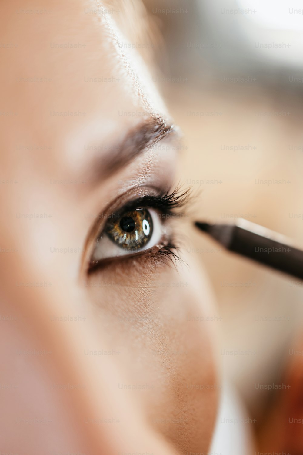 Make-up-Prozess. Professioneller Künstler, der Make-up auf Gesicht und Auge des Modells aufträgt. Extreme Nahaufnahme Makroaufnahme des schönen Frauenauges. Kurze Tiefenschärfe.