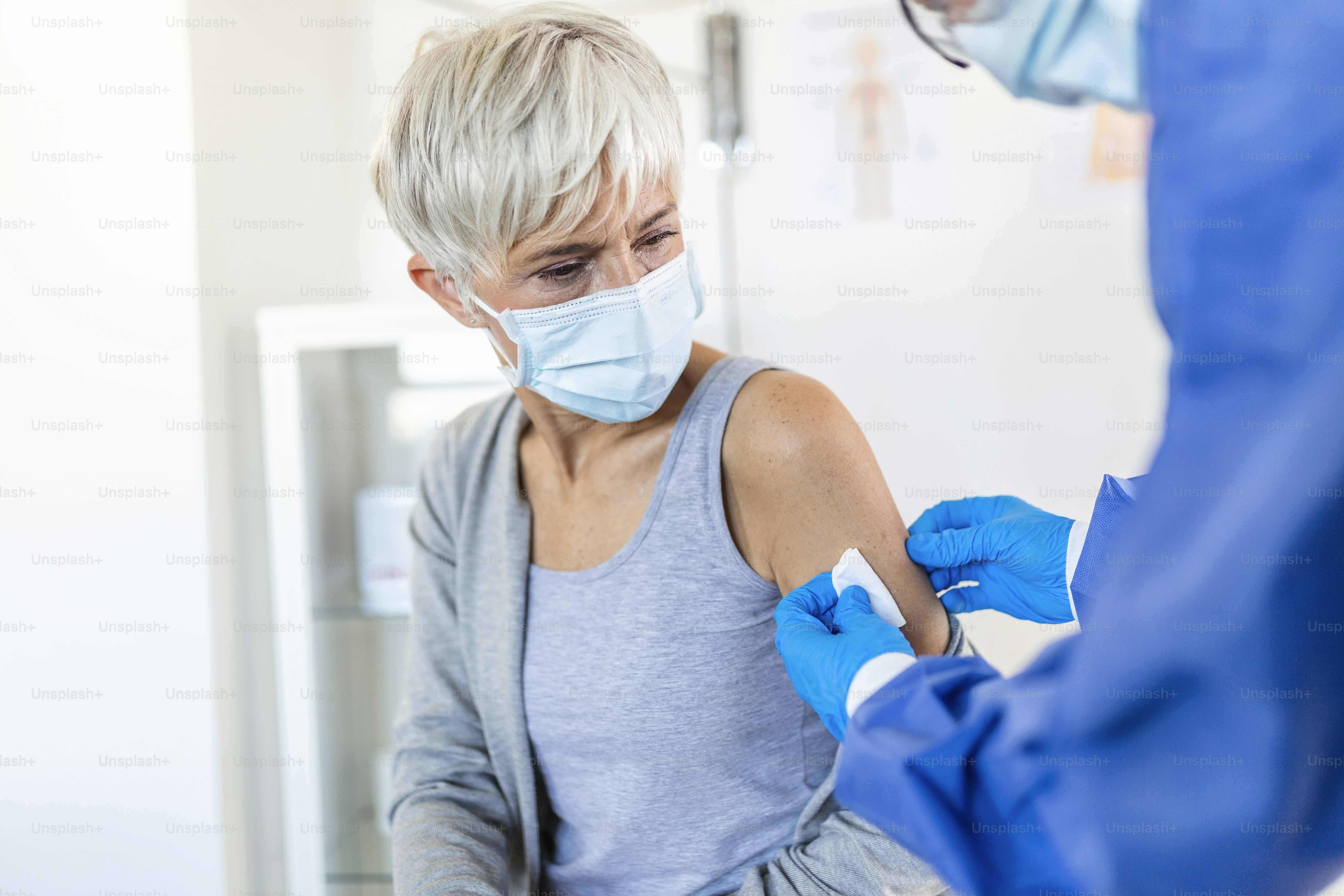 Close up of a Doctor making a vaccination in the shoulder of patient, Flu Vaccination Injection on Arm, coronavirus, covid-19 vaccine disease preparing for human clinical trials vaccination shot.