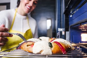 mexican woman baking a traditional rosca de reyes or epiphany cake on the oven in kitchen at home for Kings Day in Mexico Latin America