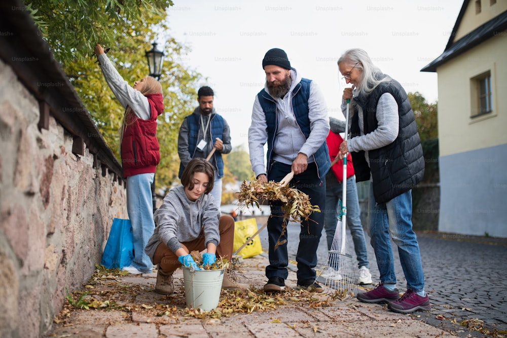 Eine bunt gemischte Gruppe glücklicher Freiwilliger räumt die Straße auf, gemeinnütziges Konzept