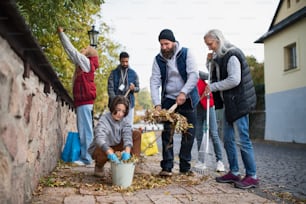 Eine bunt gemischte Gruppe glücklicher Freiwilliger räumt die Straße auf, gemeinnütziges Konzept