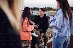 A teenagers hanging on rooftop and drinking beer.