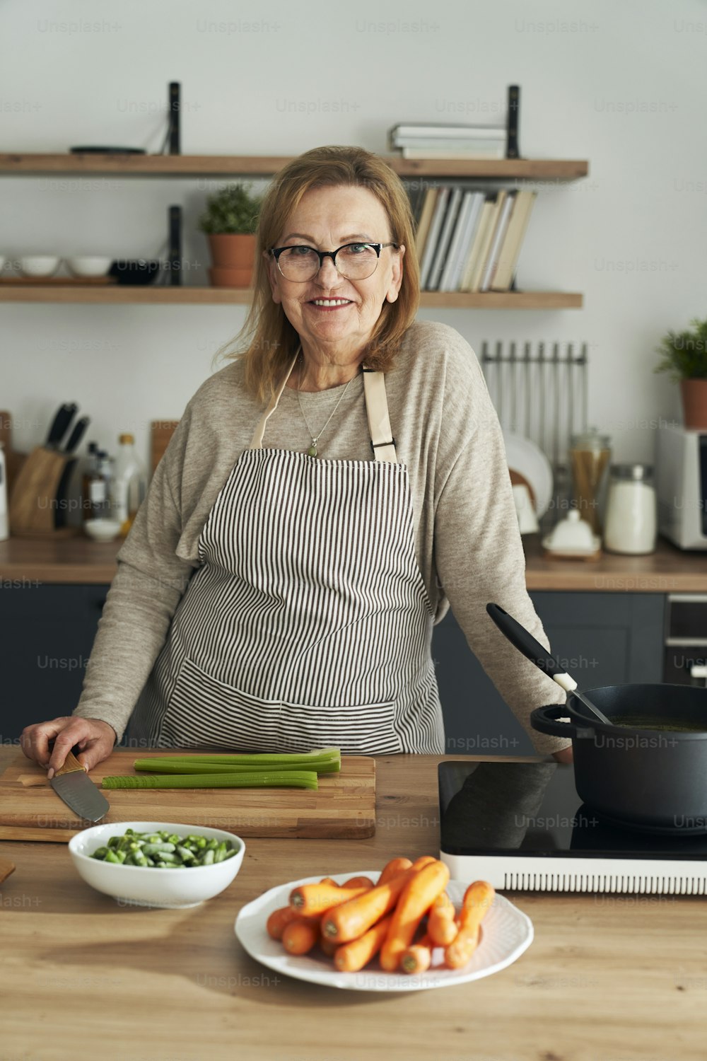 Vertical portrait of caucasian senior woman leaning in the kitchen island