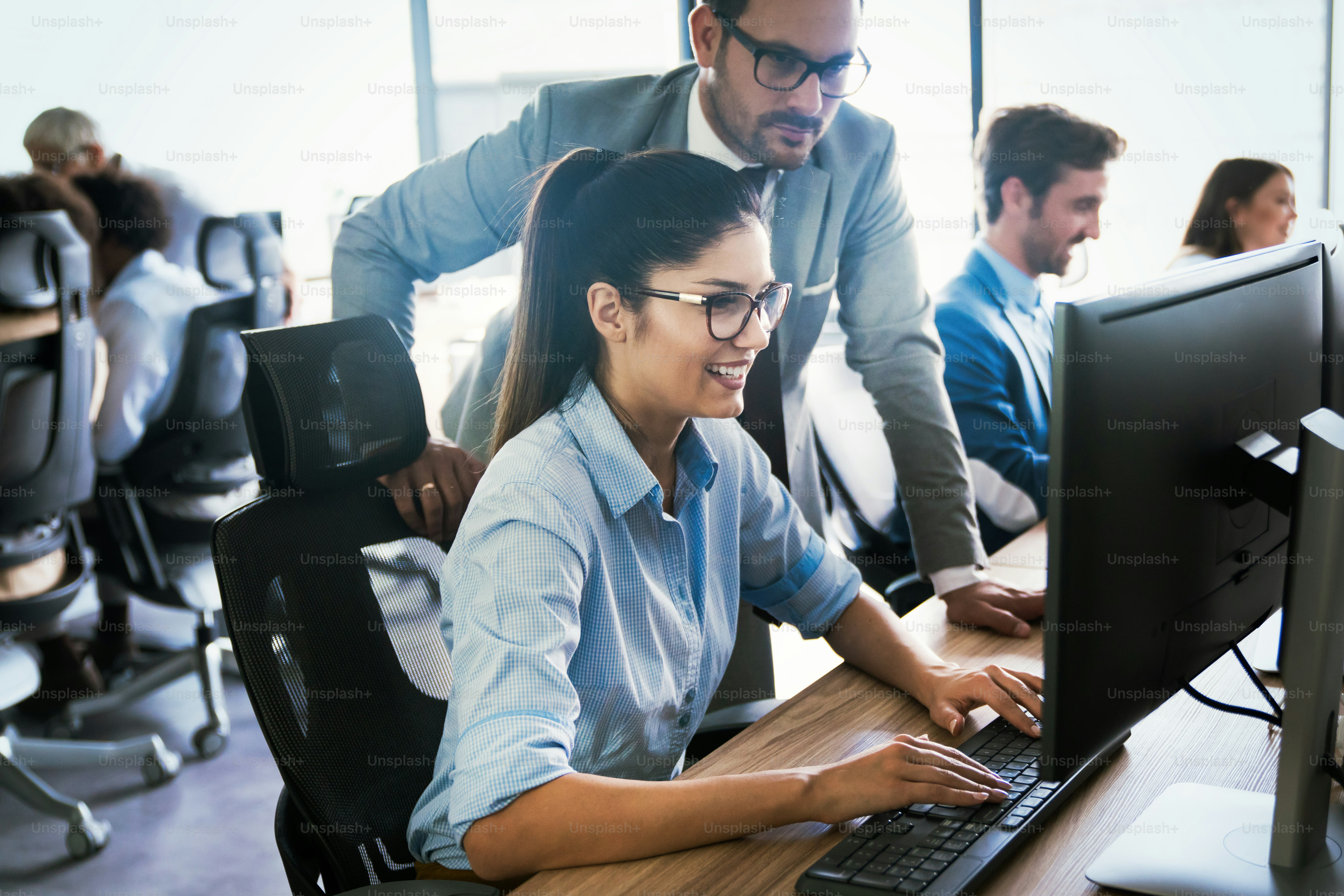 Happy business people working, having fun and chatting at workplace office