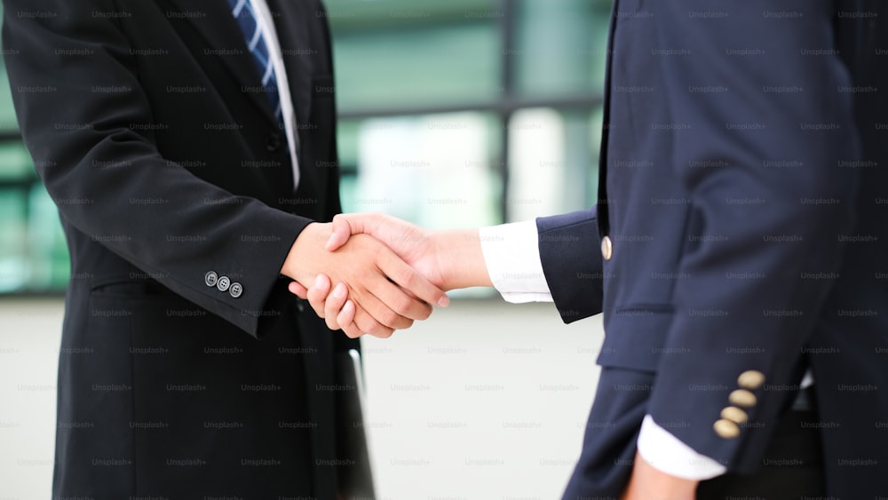 Businessmans handshake. Successful businessmen handshaking after good deal. Business partnership meeting concept.