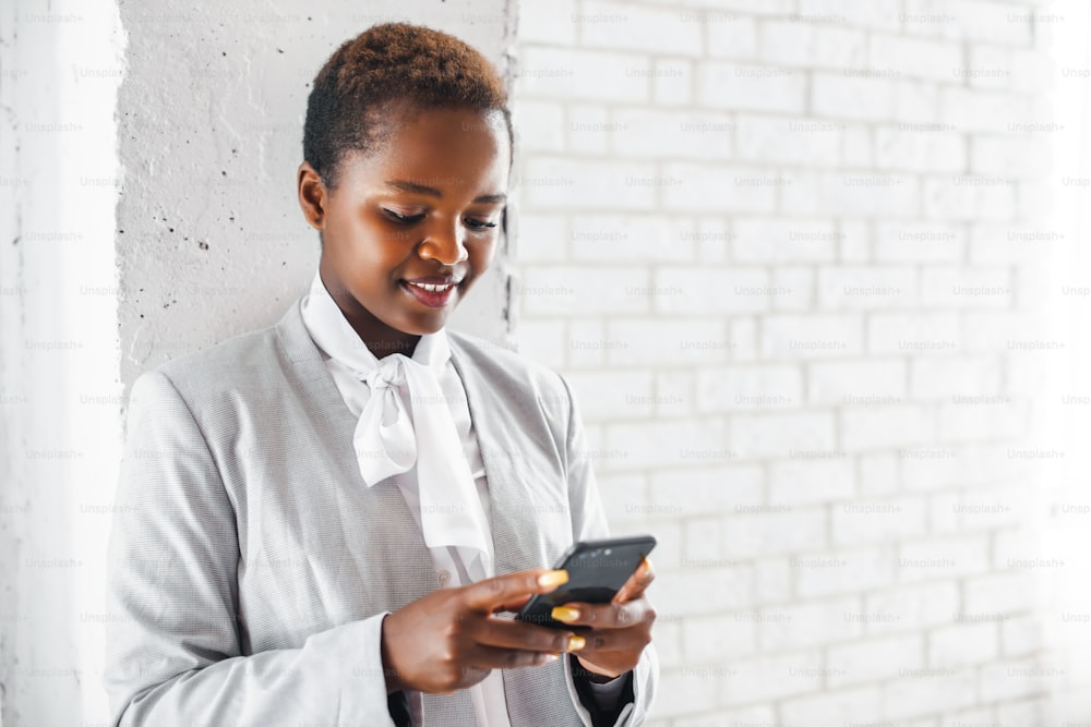 Comunicación en línea. Comunicación móvil. Mujer de negocios negra usando un teléfono. Concepto de negocio