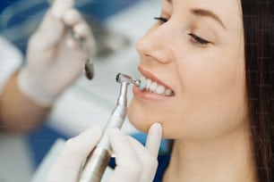 Visão geral da prevenção da cárie dentária. Menina na cadeira do dentista durante um procedimento de descamação dentária. Sorriso Saudável.
