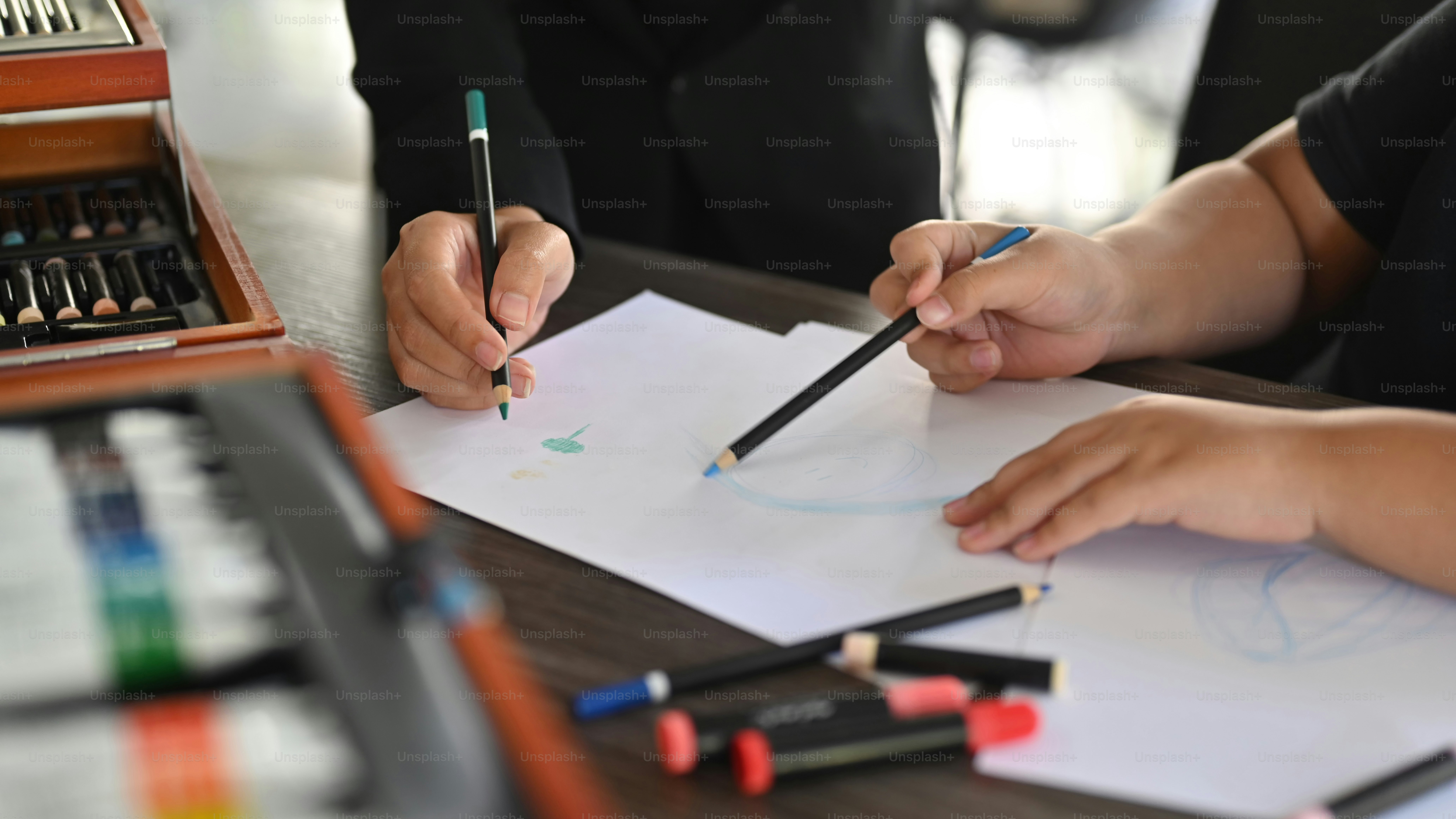 Close up view art teacher helping  helping her student drawing.