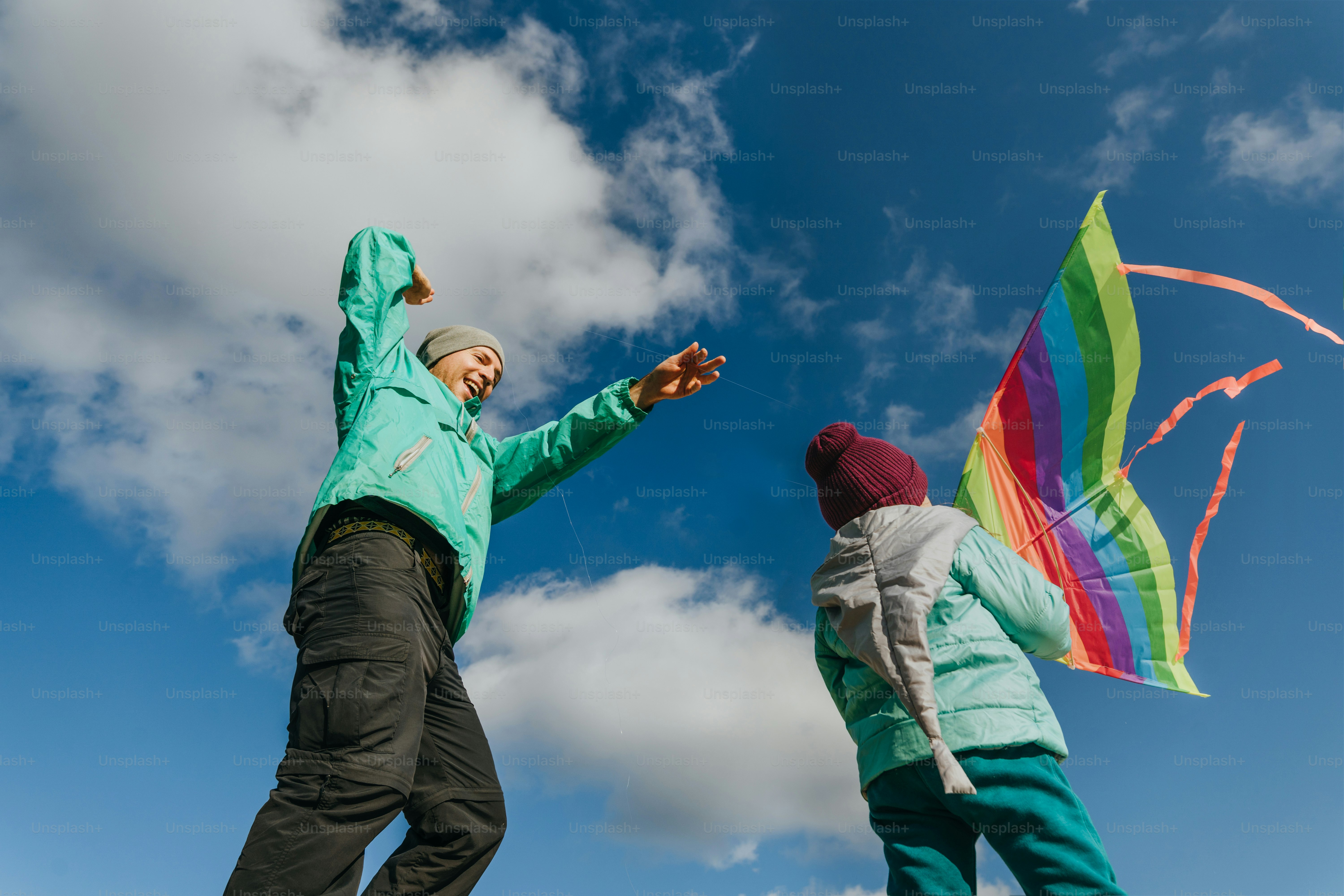 Father with his 5 years old daughter flying a kite on the sand beach. Happy family activities outdoor. Parenthood concept.