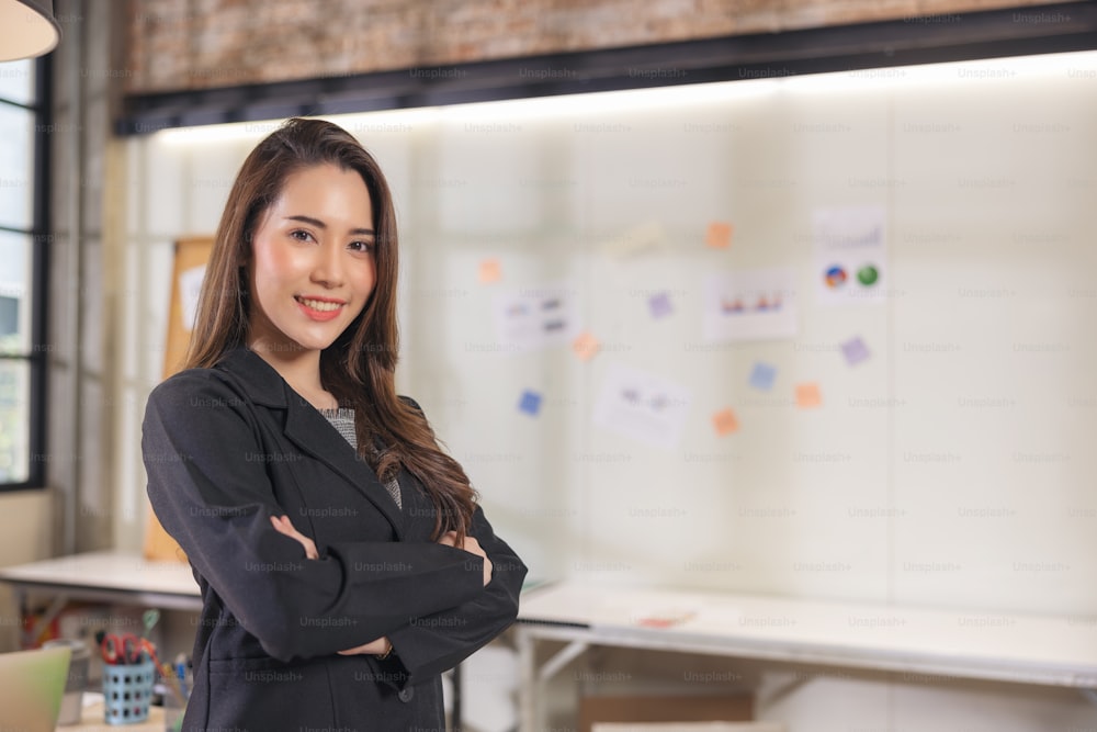 Modern businesswoman at the office, smiling female boss posing for a company photograph, self-assured successful woman at work
