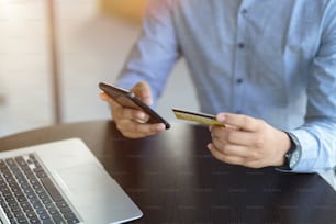 A man holding smartphone and credit card. online banking, online payment, internet money transaction, transfer money. cropped image
