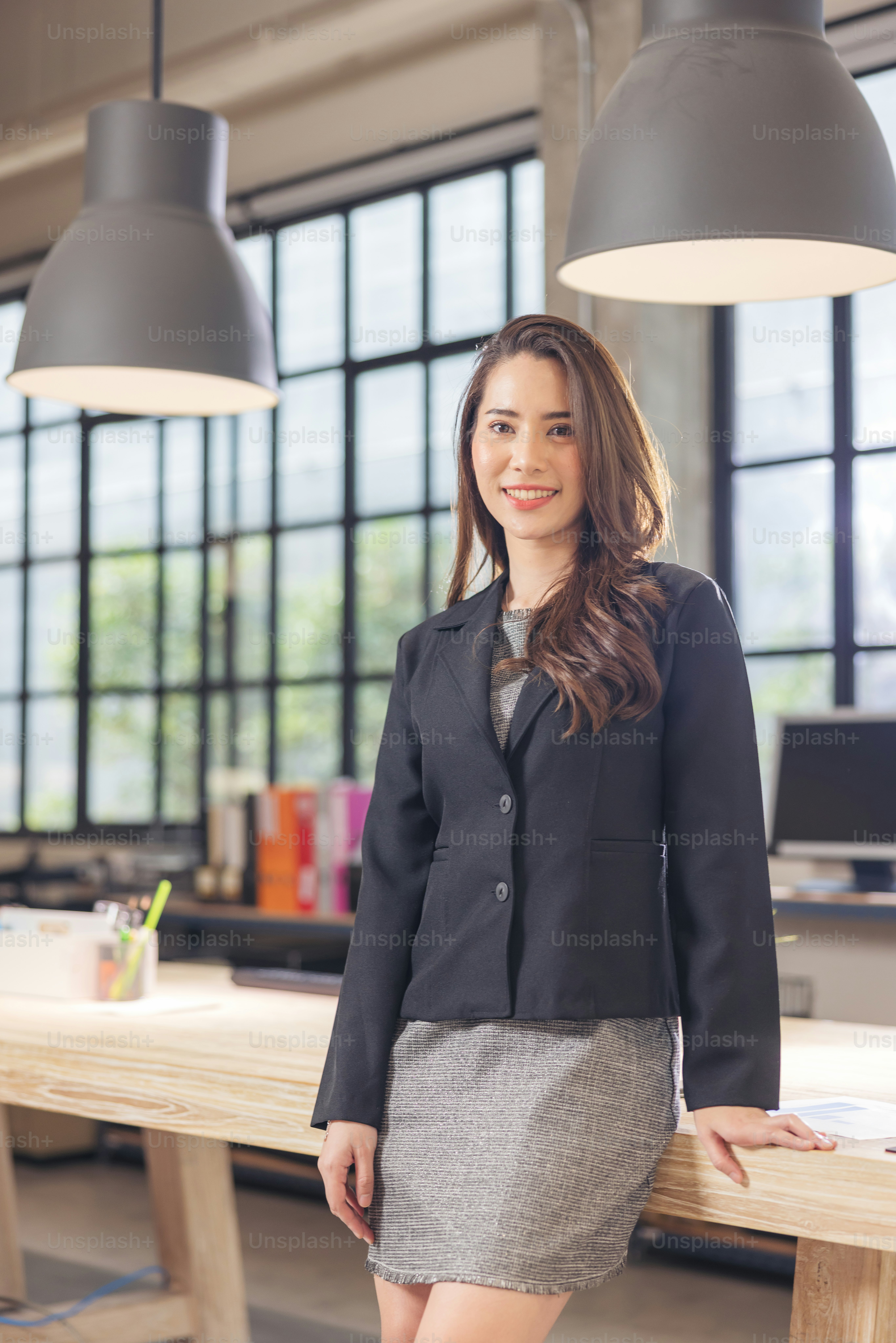 Modern businesswoman at the office, smiling female boss posing for a company photograph, self-assured successful woman at work