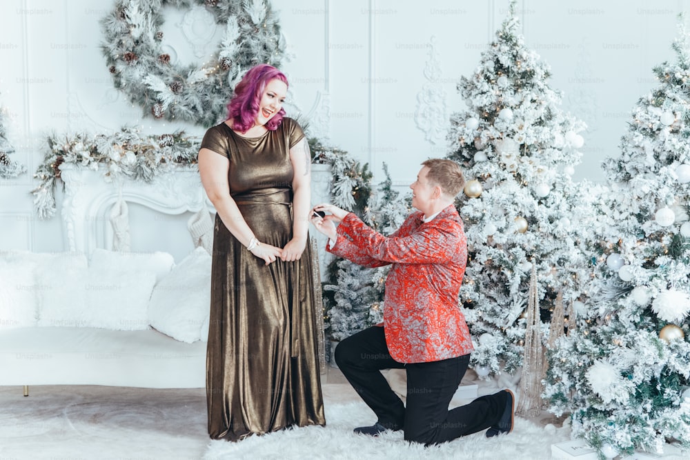 同性愛者のゲイブッチ女性は、彼女と結婚するために彼女のガールフレンドを提案し、指輪で彼女の箱を与えます。クリスマスや新年の冬休みを祝うLGBTQレズビアンのカップル。本物の本物のポジティブな感情